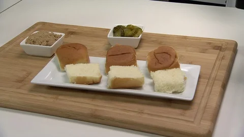 Mini BBQ pulled pork sliders being assembled on bun 1 Video stock 102136591