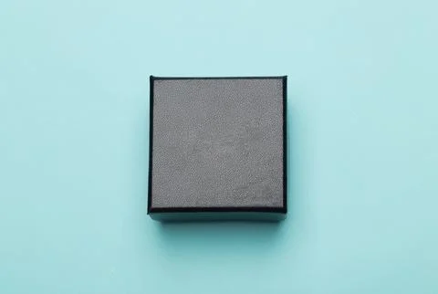 Mini black box product packaging isolated on blue background. Flat lay Top vi Stock Photos