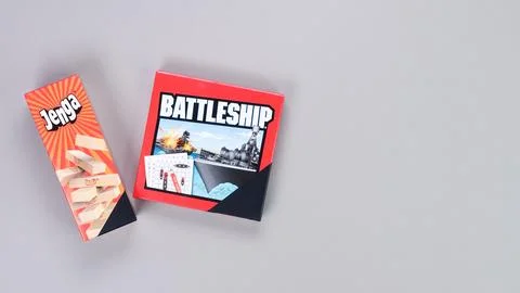 Mini board games on grey background. Fun games to play with kids. Boxes of Jenga Stock Photos