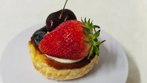 Mini burnt cheesecake topped with fresh strawberry and dark cherry. 스톡 동영상 339781133