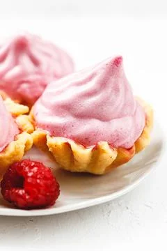 Mini cakes baskets with raspberry cream on white plate Stock Photos