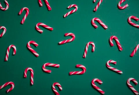 Mini candy canes on a green background Stock Photos