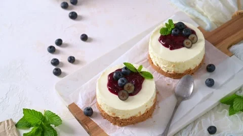Mini cheesecakes with blueberry jam fresh berries and mint Stock Footage 341710298