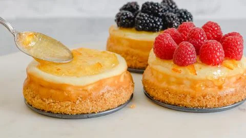Mini cheesecakes close-up. Topping cheesecakes with orange marmalade, fresh.. Stock Photos