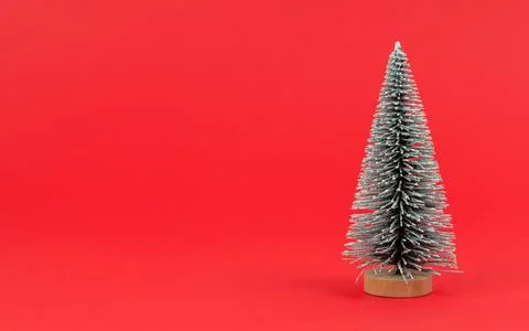 Mini Christmas artificial tree on red background close-up Stock Photos