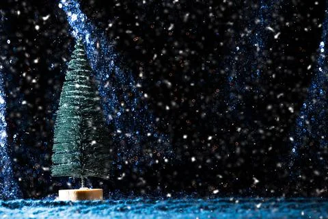 Mini Christmas tree on sequin and knit background with snow Stock Photos
