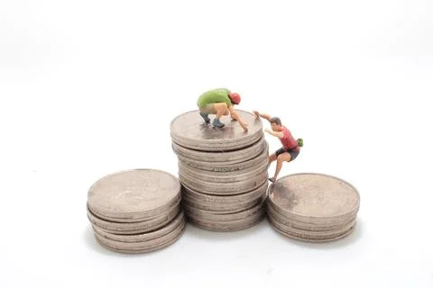 A mini climbers team climbing on stack of coins Stock Photos
