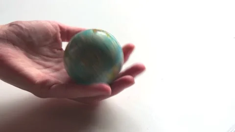 A mini copy of a globe lies in the hands closeup. The hand or hands are play Stock Footage 152581267