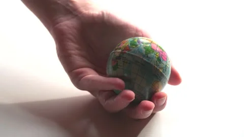 A mini copy of a globe lies in the hands closeup. The hand or hands are play Stock Footage 152581288