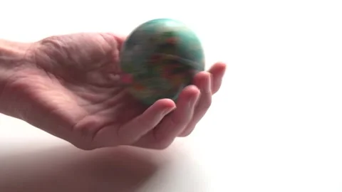 A mini copy of a globe lies in the hands closeup. The hand or hands are play Stock Footage 152581329