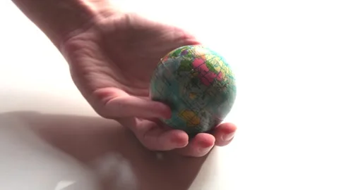 A mini copy of a globe lies in the hands closeup. The hand or hands are play Stock Footage 152581354