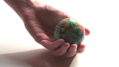 A mini copy of a globe lies in the hands closeup. The hand or hands are play Stock Footage 152581412