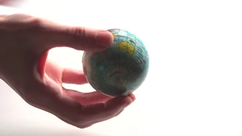 A mini copy of a globe lies in the hands closeup. The hand or hands are playi Stock Footage 152581656