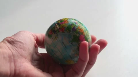 A mini copy of a globe lies in the hands closeup. The hand or hands are playi Stock Footage 152584549