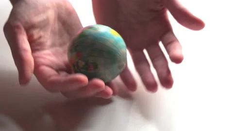 A mini copy of a globe lies in the hands closeup. The hand or hands are playi Stock Footage 152584634