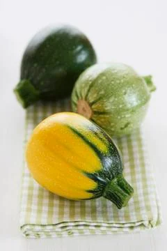 Mini courgettes in three colours on a tea towels Foto stock