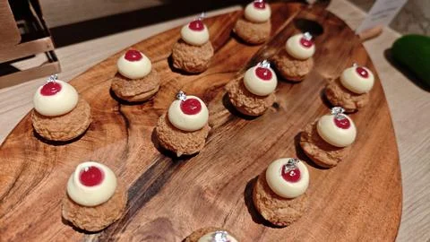 Mini Cream Cakes with Raspberry Topping on Wooden Dessert Buffet Display Stock-Fotos