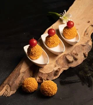 Mini crispy appetizer balls topped with cherry tomatoes Stock Photos