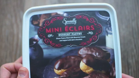 Mini eclairs small size bites by Aldi private label brand product packaging Stock Footage 336758159