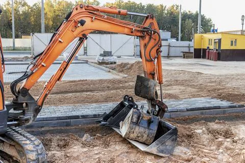 Mini excavator at the construction site. Compact construction equipment Stockfoto's
