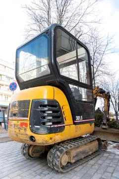 Mini excavator on the construction site. Replacement of paving slabs and re.. Stock Photos