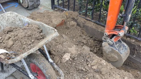A mini excavator is digging the earth. Video stock 85774300