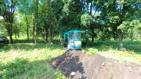 Mini excavator digs a trench 스톡 동영상 135439773