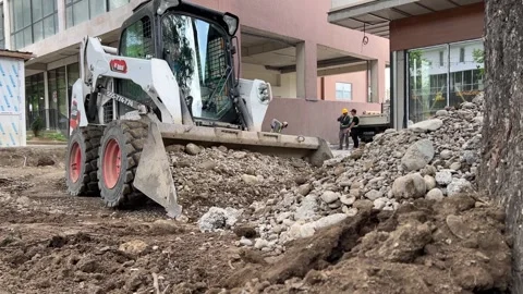 Mini excavator dumps rubble, dirt, soil into pile with bucket Stock Footage 308562167