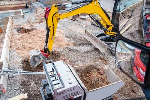 Mini excavator for moving soil on a construction site Stock Photos