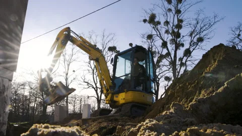 Mini excavator at work next to a large dirt pile Stock Footage 236616785