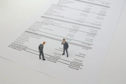 The mini figure stand on the balance sheet Stock Photos