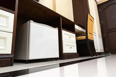 Mini fridge in low angle view, inside its empty shelves placed under wooden.. Stock Photos