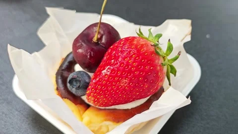 Mini fruit tart with strawberry, cherry, and blueberry on greaseproof paper. Stock Footage 339780286