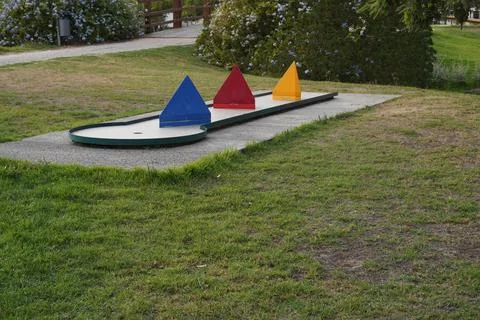 Mini golf course with colorful triangular obstacles on green grass. Stock Photos