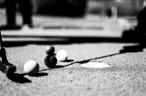 Mini golf game with several colored balls in the way of a putter lined up. Foto stock
