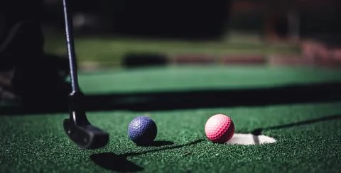 Mini golf game with several colored balls in the way of a putter lined up. Stockfoto's