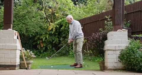 Mini golf, swing and senior man in backyard for sports, training and relax with Stock Footage 307819261
