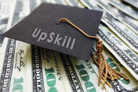 Mini graduation cap with Upskill text on money Stock-Fotos