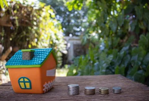 Mini house model and stack of coins. Business risk management. Property inves Stock Photos