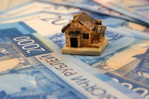 Mini house on stack of coins. Concept of Investment property. Stock Photos