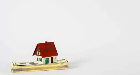 A mini-house on a stack of dollar bills. The concept of investment property Stock Photos