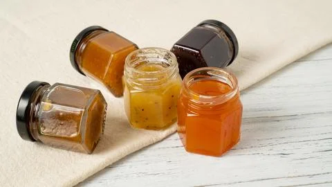 Mini jam jars. Tiny jars of jam. Different fruit jams in glass bottles 写真素材