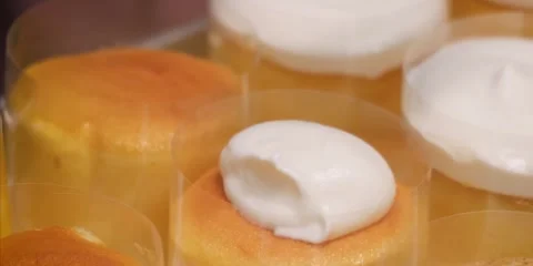 Mini Japanese Souffle Cheesecakes Wrapped in Acetate Film with Whipped Cream Top Stock-Footage 343588962