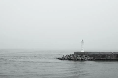 Mini Lighthouse on the coast. small lighthouse on the pier in black and white Stock Photos