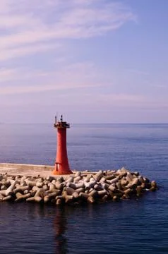 Mini Lighthouse on the coast. small red lighthouse on the pier Stock Photos
