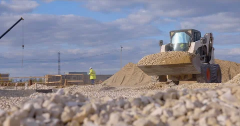Mini loader bobcat transports crushed stone to different construction places Stock Footage 161960002