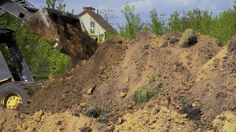 Mini Loader doing earth works with country house on background Stock Footage 107653063