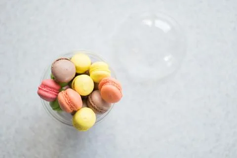 Mini macarons cakes in a package slide on a gray background Stock Photos