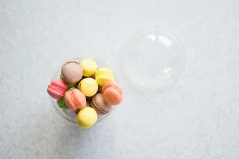 Mini macarons cakes in a package slide on a gray background Stock Photos