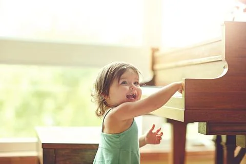 Mini maestro in the making. an adorable little girl playing on the piano at home Stock Photos
